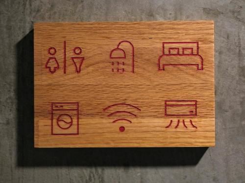 a wooden cutting board with drawings on it at Photohostel in Bangkok