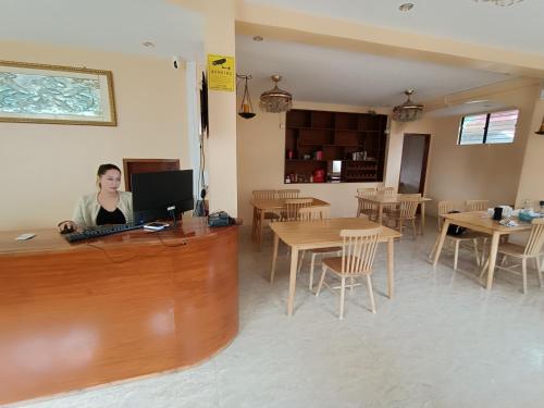 a woman sitting at a desk with a computer at Speed 8 Inn Moalboal in Moalboal