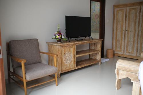 a living room with a tv and a chair at Kubu Garden Suites & Villas Nusa Dua in Nusa Dua