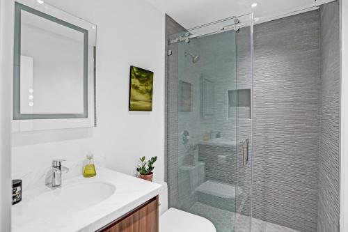 uma casa de banho com um chuveiro, um lavatório e um WC. em Stylish Luxury Tropical Junior Suite em Fort Lauderdale