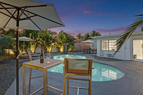 a table and chairs next to a swimming pool at Stylish Luxury Tropical Junior Suite in Fort Lauderdale