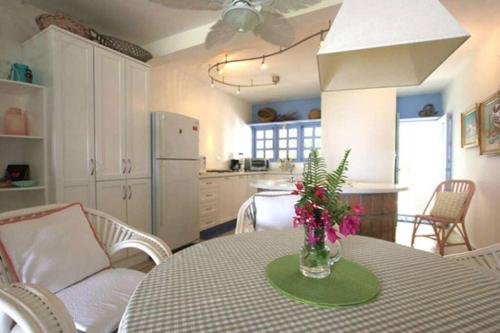 a kitchen with a table with a vase of flowers on it at Cabarete Beachfront Condos Nanny Estate A3 in Cabarete