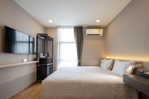 a hotel room with a bed and a window at fyn park hotel in Makkasan