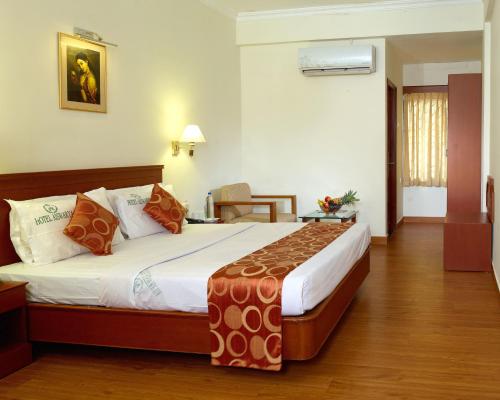 um quarto com uma cama grande num quarto em Hotel Aiswarya em Cochin