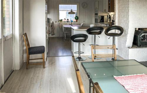 a living room with a table and chairs and a kitchen at 3 Bedroom Cozy Home In Svanesund in Svanesund