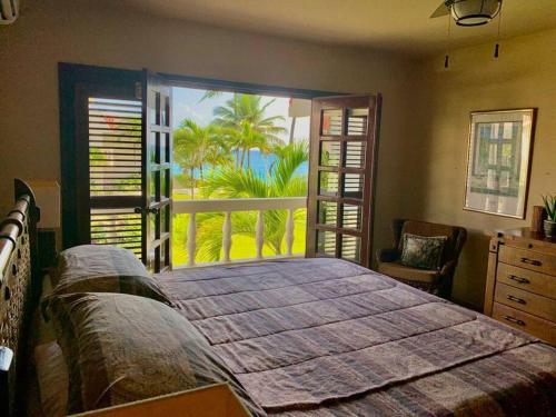 - une chambre avec un grand lit et une vue sur l'océan dans l'établissement Cabarete Beachfront Condos Nanny Estate A7, à Cabarete