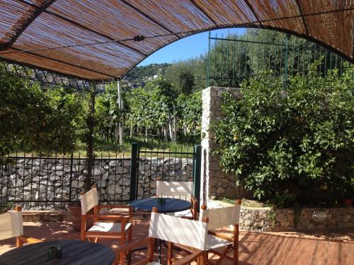 a patio with chairs and tables and an archway at Residence Dei Fiori in Pietra Ligure