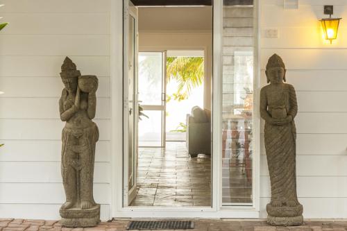 two statues on the front porch of a house at Drift Beach House Getaway in Holloways Beach