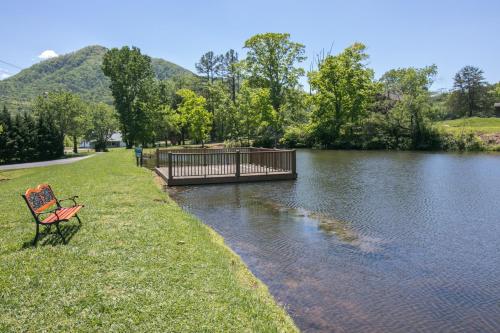 a red bench sitting on the grass next to a river at The Homeplace in Sevierville