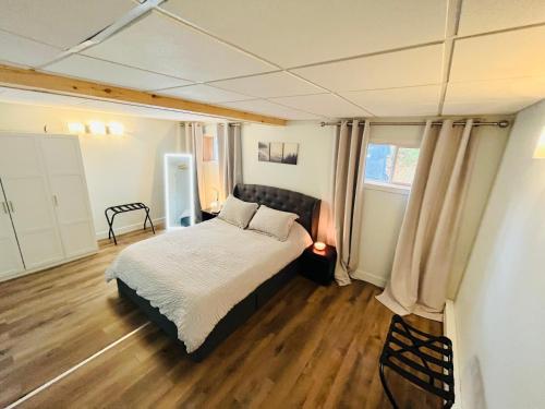 een slaapkamer met een bed en houten vloeren bij Sweet Home des Suites North Hatley in North Hatley