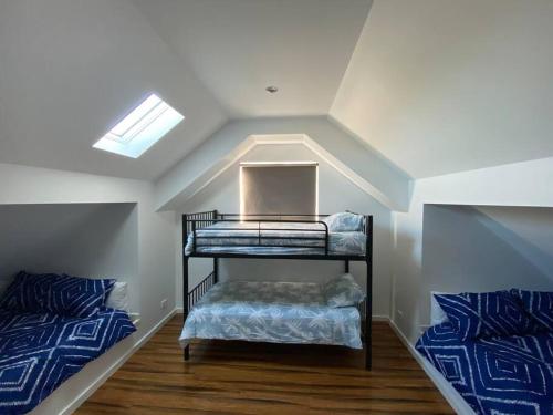 a attic room with two bunk beds and a skylight at Baja Beach Lodge in Indented Head