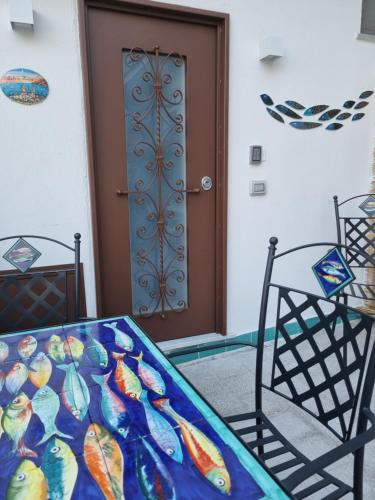 a room with a door and a table and chairs at Cala Di Luna House in Vietri sul Mare