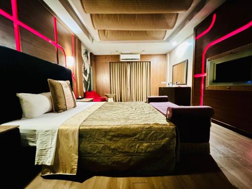 a hotel room with a large bed with pink lighting at Motel Fabulous in Suao