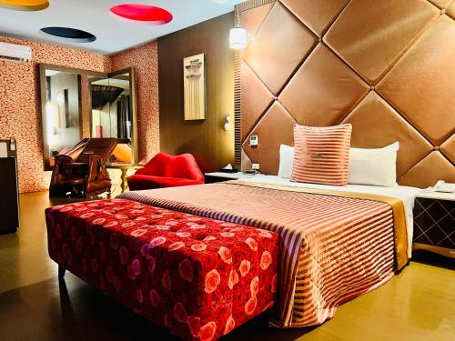 a hotel room with a large bed with a red bench at Motel Fabulous in Suao