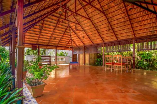 a large wooden pavilion with tables and chairs at Rockholm at the Light House Beach in Kovalam