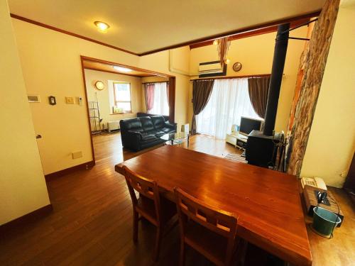 a living room with a wooden table and a couch at Cottage Hotel Fenice Hakuba in Hakuba
