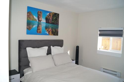 um quarto com uma cama branca e um quadro na parede em Ground Level One Bedroom Suite em Surrey