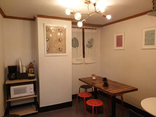a kitchen with a table and two stools and a microwave at Hangeul Guesthouse in Seoul