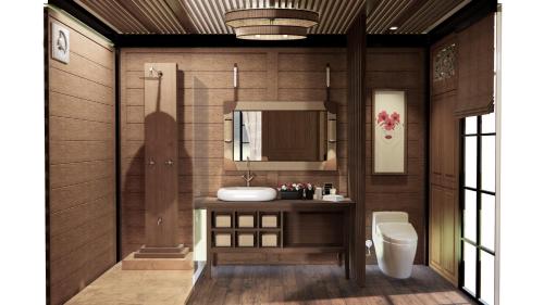 a bathroom with a sink and a mirror and a toilet at Jawa Jiwa G-Land Resort in Dadapan