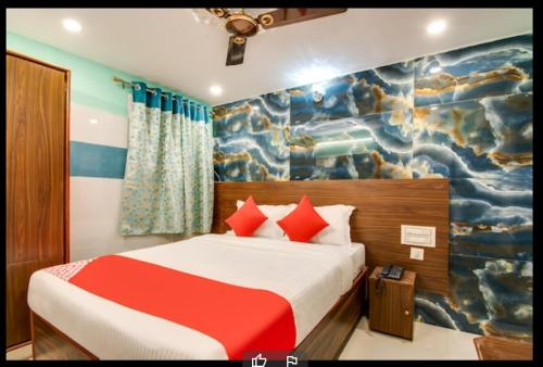 a bedroom with a bed with a painting on the wall at Hotel Sri Grand 