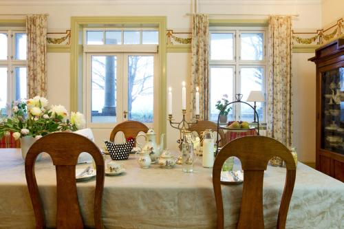 a dining room with a table with chairs and flowers at Tiendegaarden Møns Klint in Borre