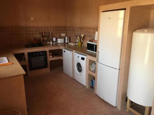 uma cozinha com um frigorífico branco e uma máquina de lavar louça em Berberbayt lodge maison privé em Tinghir