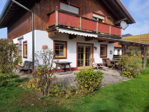 een huis met een balkon en een tafel ervoor bij Ferienhaus Inntal in Oberaudorf