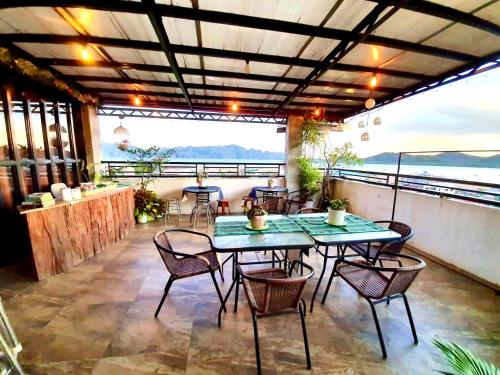 a patio with tables and chairs and a view of the ocean at Kalis Viewpoint Lodge Coron in Coron