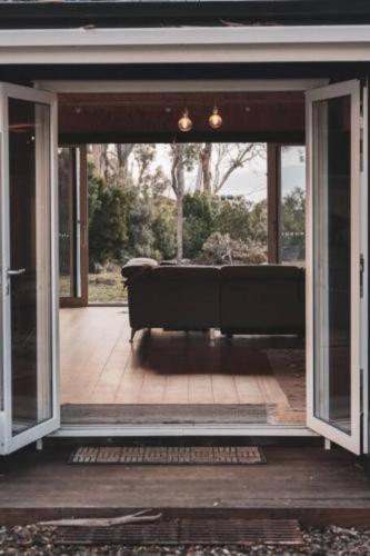 an open door to a porch with a couch at Seagrass on Sunset Bay in Alonnah