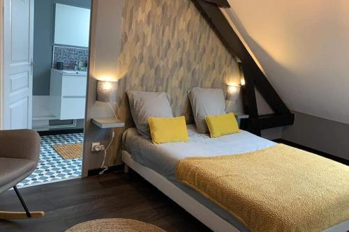 38 Maison entière,place de parking et garage pour moto velo في دونكيرك: غرفة نوم بسرير مع وسادتين صفراء