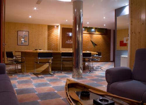 eine Lobby mit einer Bar mit Stühlen und einem Tisch in der Unterkunft Hotel A. G. Porcillan in Ribadeo