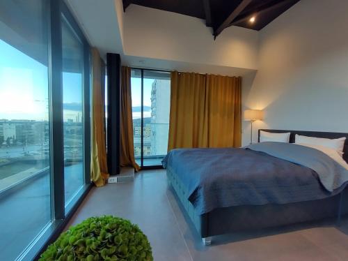 a bedroom with a bed and a large window at Sky City Panoramic in Iaşi