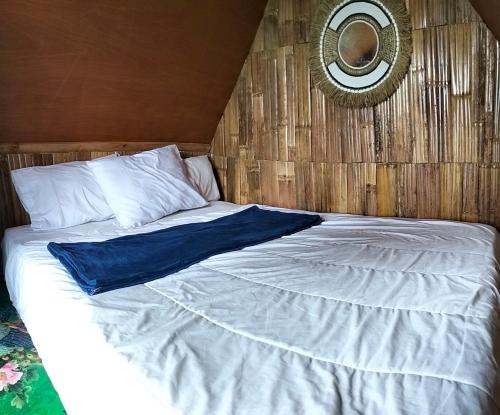 a bedroom with a large white bed with a mirror at Wanagiri Campsite in Gitgit