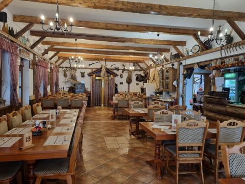 a dining room with wooden tables and chairs at Kemencés Fogadó in Tardos