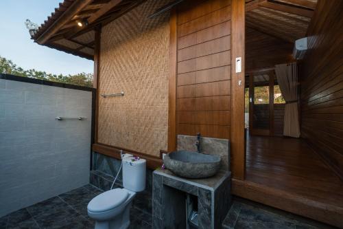 a bathroom with a sink and a toilet at Gatri Hut in Nusa Lembongan