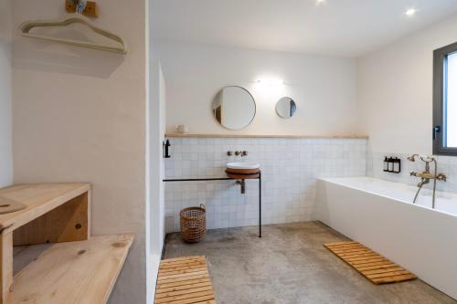 bagno con vasca, lavandino e specchio di VILLA FLAKA Boutique Hôtel a Cargèse