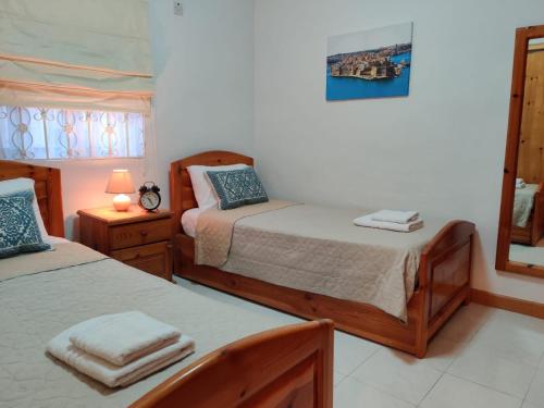 a bedroom with two beds and a mirror at In the Heart of Bugibba in St. Paul's Bay