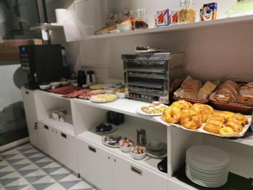 a bakery with various types of pastries on shelves at Hotel Plaza Obradoiro by Bossh! Hotels in Santiago de Compostela