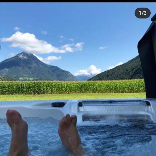 a persons feet in the water in a hot tub at Deluxefort für 10 Gäste mit eigenem Whirlpool und Fasssauna in Imst