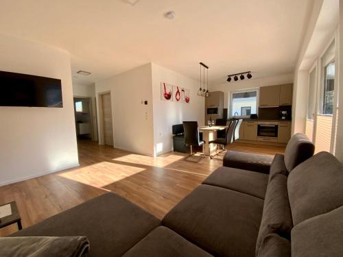 ein Wohnzimmer mit einem Sofa und einer Küche in der Unterkunft Deluxefort für 10 Gäste mit eigenem Whirlpool und Fasssauna in Imst