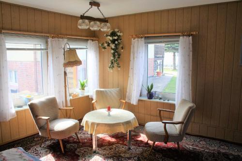 a room with chairs and a table and two windows at Ruegen_Fewo 285 in Neu Mukran