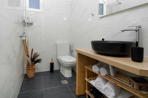 uma casa de banho com um lavatório preto e um WC. em La Rosa em Ermoupoli