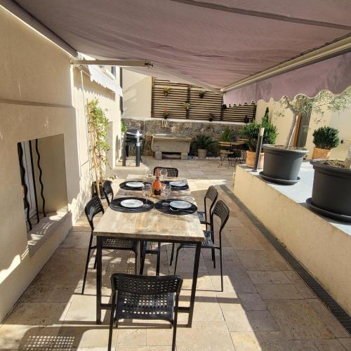 un patio avec une table et des chaises sur un patio dans l'établissement Le Sémaphore, à Saint-Raphaël