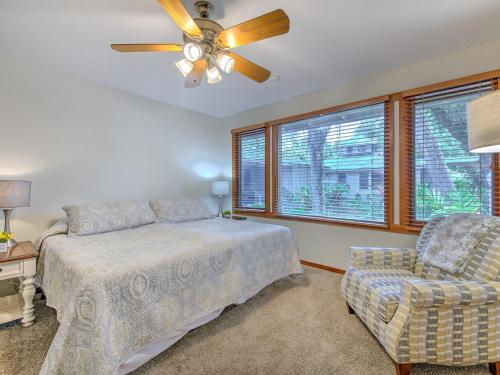 a bedroom with a bed and a ceiling fan and a chair at Riverbend Retreat Fla in Riverview