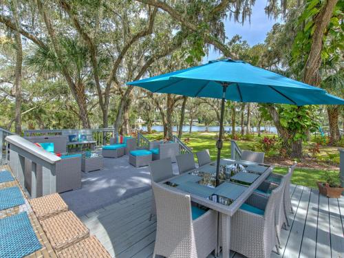 a patio with a table with a blue umbrella at Riverbend Retreat Fla in Riverview