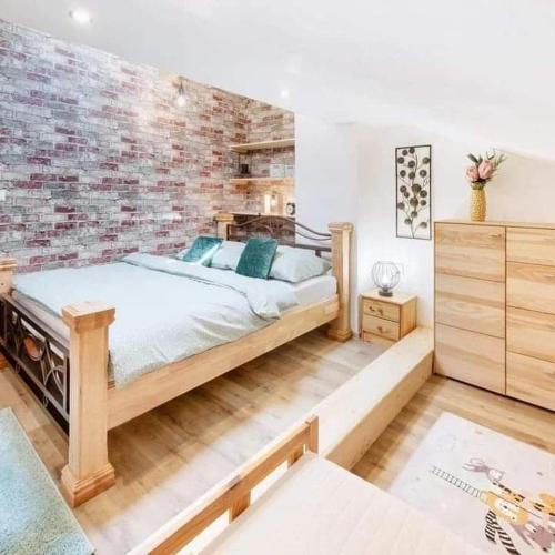 a bedroom with a bed and a brick wall at Wellness Apartmány Andrea in Zdíkov