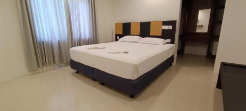 1 dormitorio con 1 cama grande con sábanas blancas en Ras Village, en Rasdu