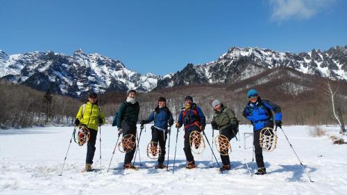 a group of people posing for a picture in the snow at 宿屋白金家 yadoya-shiroganeya 1日1組限定2名から8名様まで 全館貸切り 伝統的建造物の旅籠宿 Traditional culture experience in Nagano