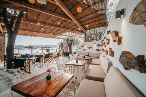 a restaurant with a wooden table and chairs at Coralli Seaside Resort in Livadakia