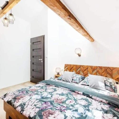 a bedroom with a large bed with a floral bedspread at Wellness Apartmány Andrea in Zdíkov